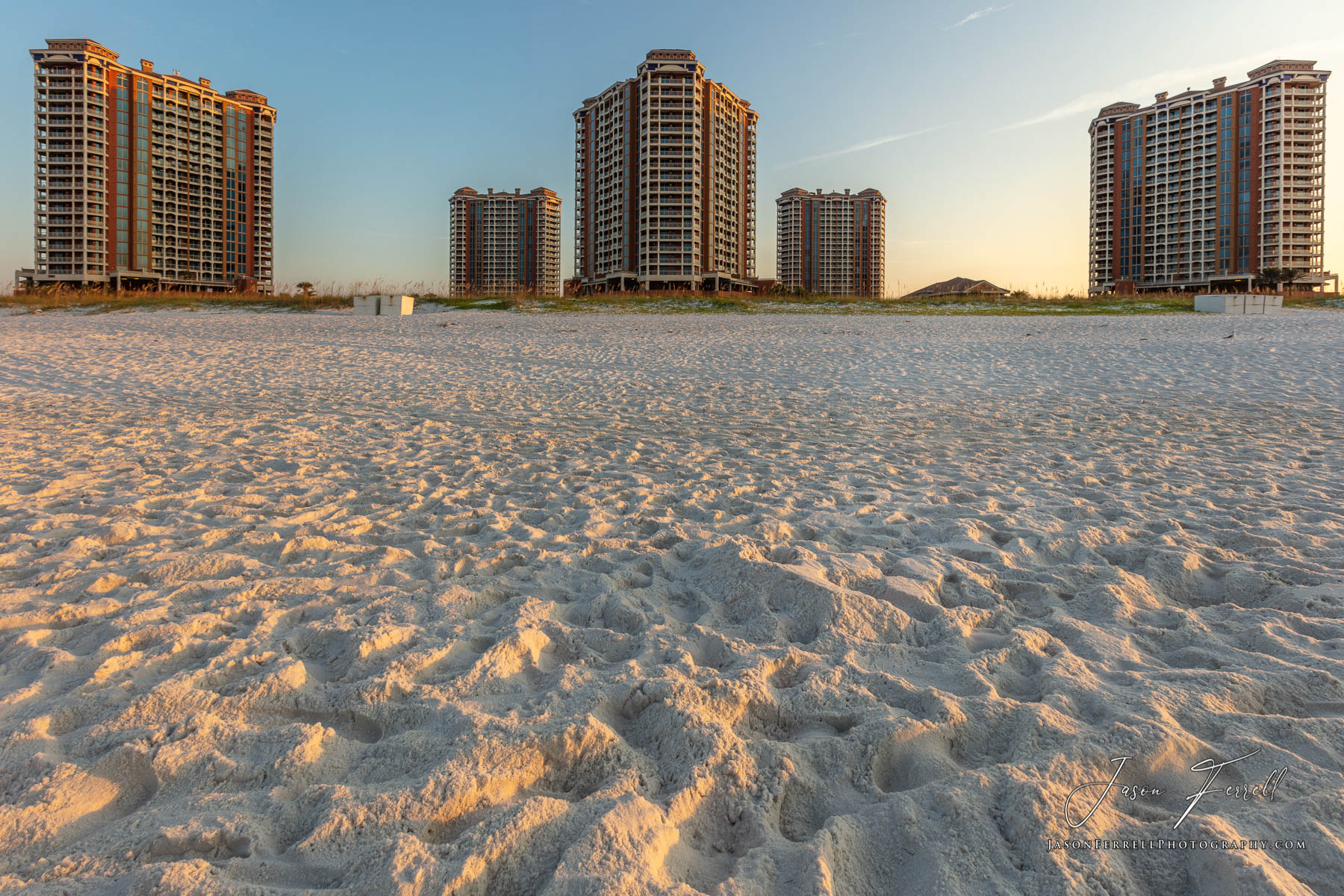 An early morning sunrise photo of the Portofino Island Resort Towers on the beach.