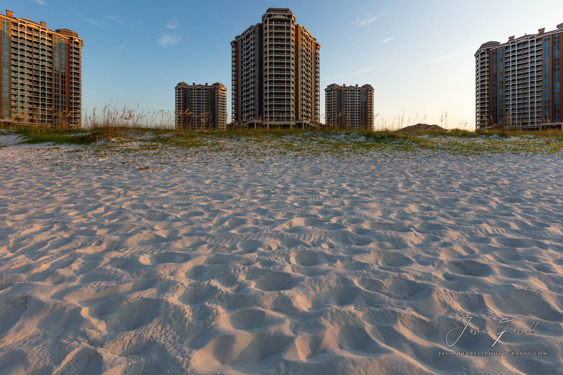 An early morning sunrise photo of the Portofino Island Resort Towers on the beach.